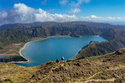Hikers at the summit of Pico Barrosa with view to the crater lake Lagoa do Fogo