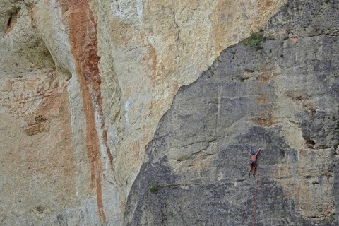 Climber on rope in rock face