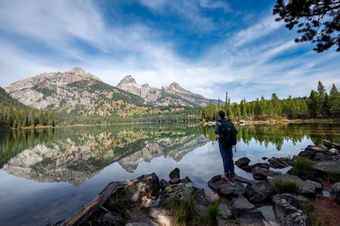 Young man standing by a lake