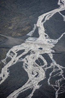 Off-road vehicle crossing the river on the highland road F249