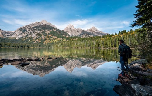 Young man standing by a lake