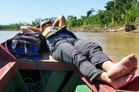 Tourist lying on the bow of a longboat