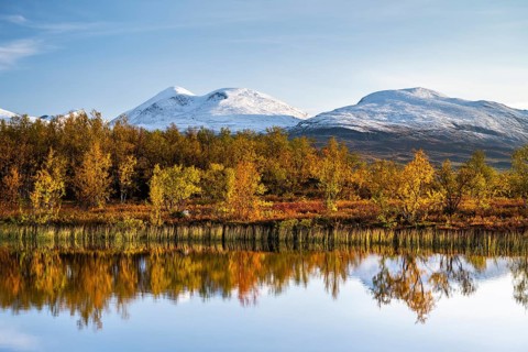 Snowy mountains in Abisko National Park reflected in lake Vuolio Njahkajavri