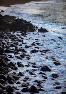 Large black lava stones in the surf on the beach of Praia de Santa Barbara