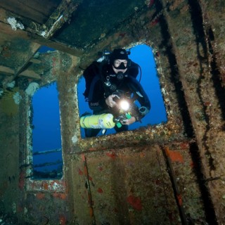 Diver views interior of shipwreck has special equipment for mixed gas diving
