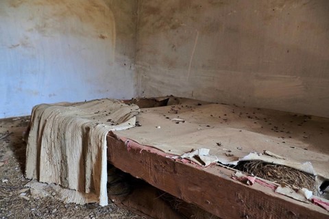 Demolished bed frame with blanket and pigeon droppings