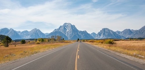Country road in front of Grand Teton Range mountain