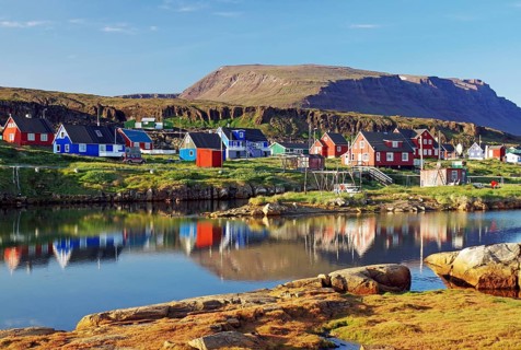 Wooden houses reflected in a calm body of water