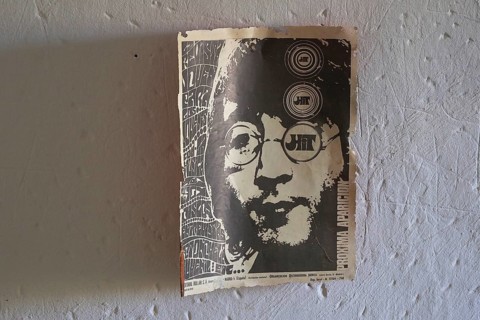 70s newspaper page with John Lennon graphic on white wall