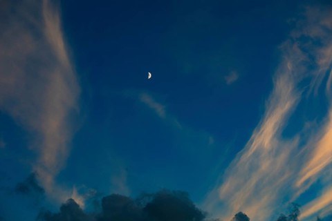 Evening sky with clouds and half moon