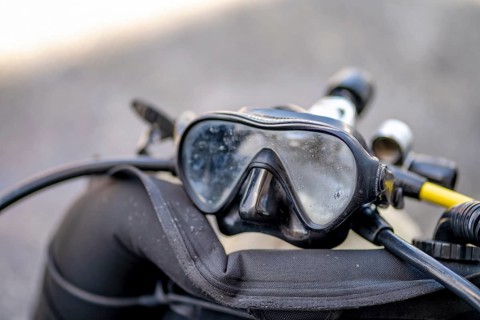 Goggles and oxygen tank with regulator for scuba divers