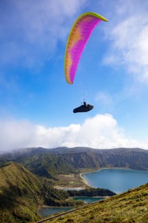 paraglider in flight over the crater lake Lagoa do Fogo