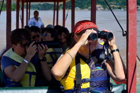 Tourist with binoculars in a longboat