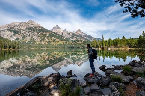 Young man standing by a lake