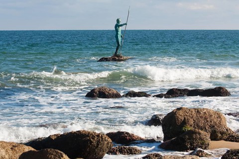 Sculpture of Neptune in sea near the beach