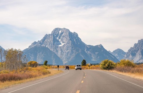 Country road in front of Grand Teton Range mountain