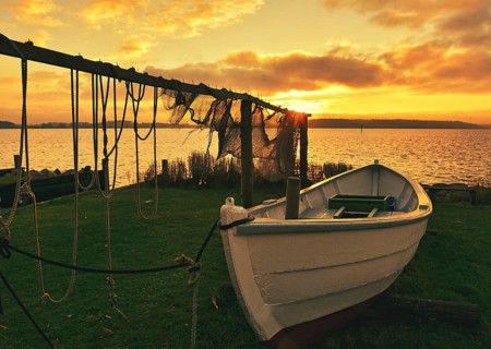 Suspended fishing nets with fishing boat in the sunset