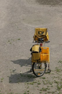 Yellow postal bike with postal bag and front luggage holder