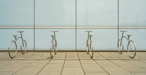 Design of aluminium bicycles in front of a bright plastic wall