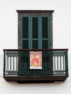 House facade with balcony and image of a saint