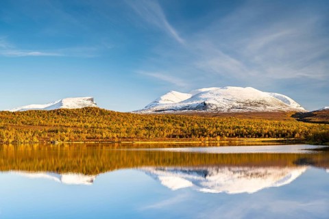 Snowy mountain group Lapporten reflected in lake Vuolio Njahkajavri