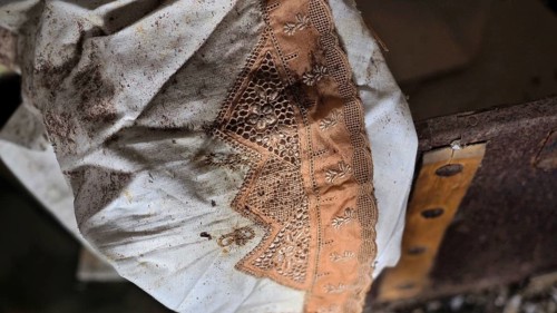 White dirty dress with hand-embroidered orange hem at the bottom