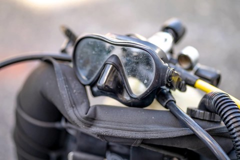 Goggles and oxygen tank with regulator for scuba divers