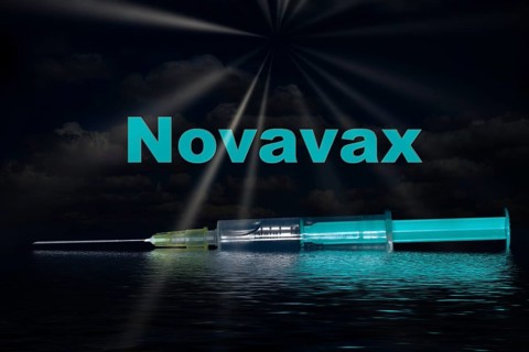 Injection syringe with the vaccine Novavax and sun rays reflected in the water