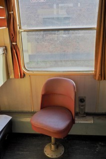 Red single seat inside an old train compartment