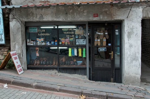 Old cobbler's shop with shop window on street with slope