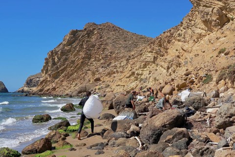 Young people collecting plastic waste on the beach