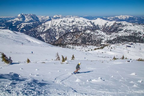 Snowboarders in the terrain next to piste 5