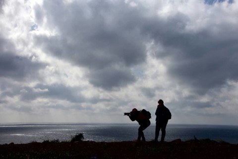 Women photographers with camera at the cloudy sea