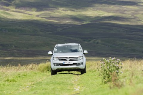 Four wheel drive VW Amarok twin cab pick up driving across upland pasture in North Yorkshire