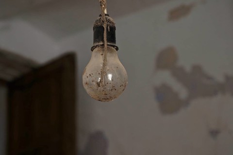 Dirty light bulb in socket hanging from the ceiling