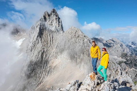 Two hikers in front of alpine panorama