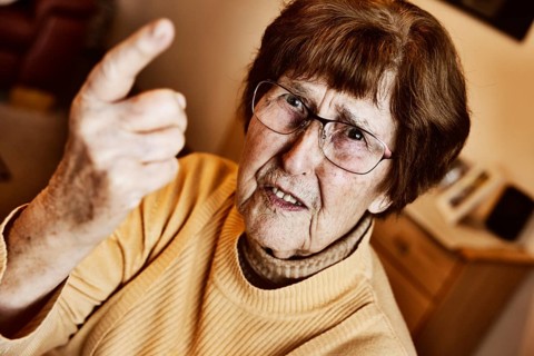 Angry senior citizen threatens with her raised index finger