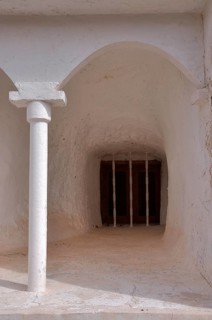 Round arch with column in front of barred window in cave house