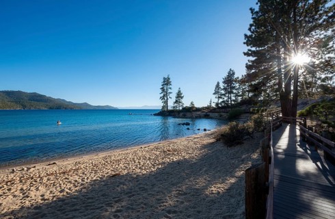 Wooden walkway on sandy beach with sun star