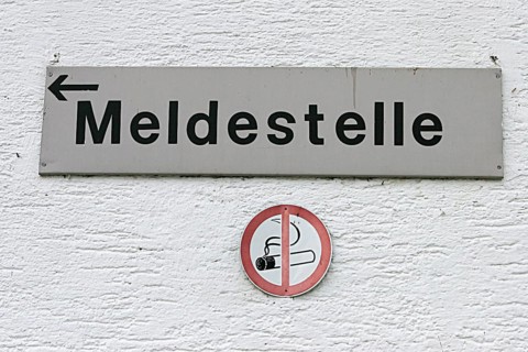 White wall with sign reporting centre and smoking ban