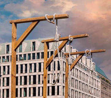 Symbolic gallows stand in front of the Brandenburg Gate during a protest rally