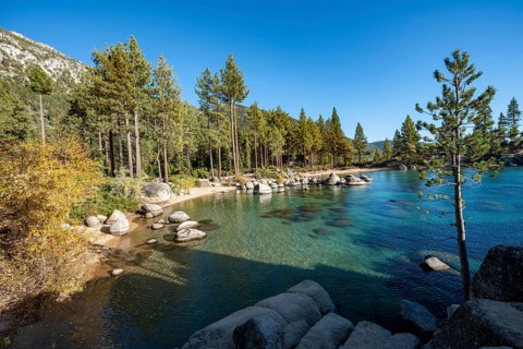 Sand beach and round stones in the water