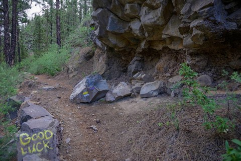 Rockfall hazard and ironic inscription on rocks good luck