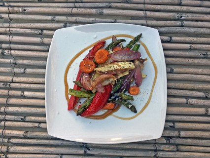 White plate Oven vegetables on straw mat with carrots