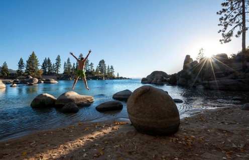 Young man in swimming trunks jumps in the air