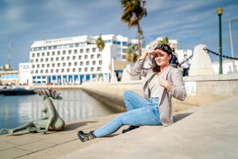 Young woman sitting by the marina in Faro