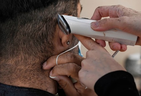 Hair clippers around the ear with mouth guard