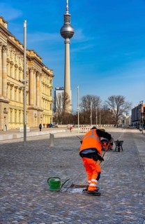 Street sweeper cleans the pavement in front of the portal at Neues Schloss