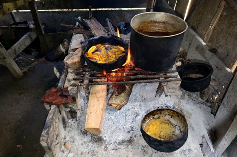 Fried bananas in a pan over a wood fire in a hut