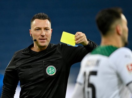 Referee Sven Jablonski shows yellow card to Ramy Bensebaini Borussia Moenchengladbach BMG